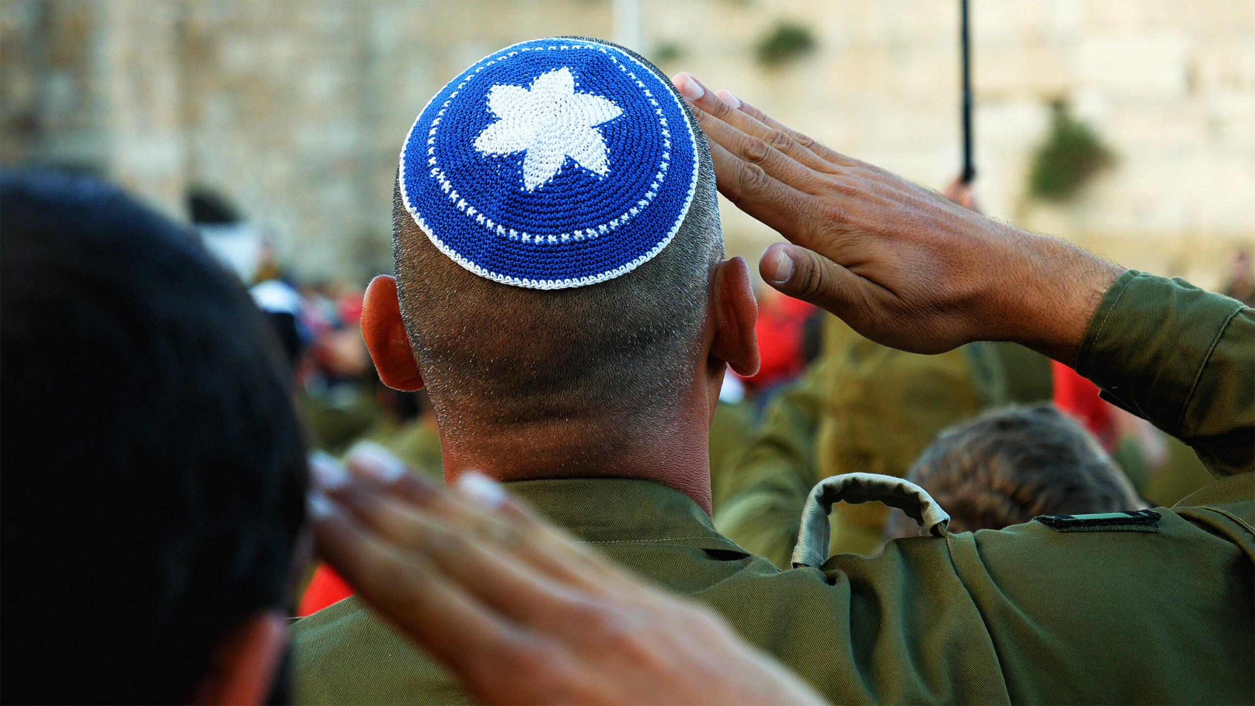 Israeli soldier military man saluting to the Western wall in Jerusalem. Western wall or Wailing wall or Kotel in Israel is the most sacred place for all jewish people.