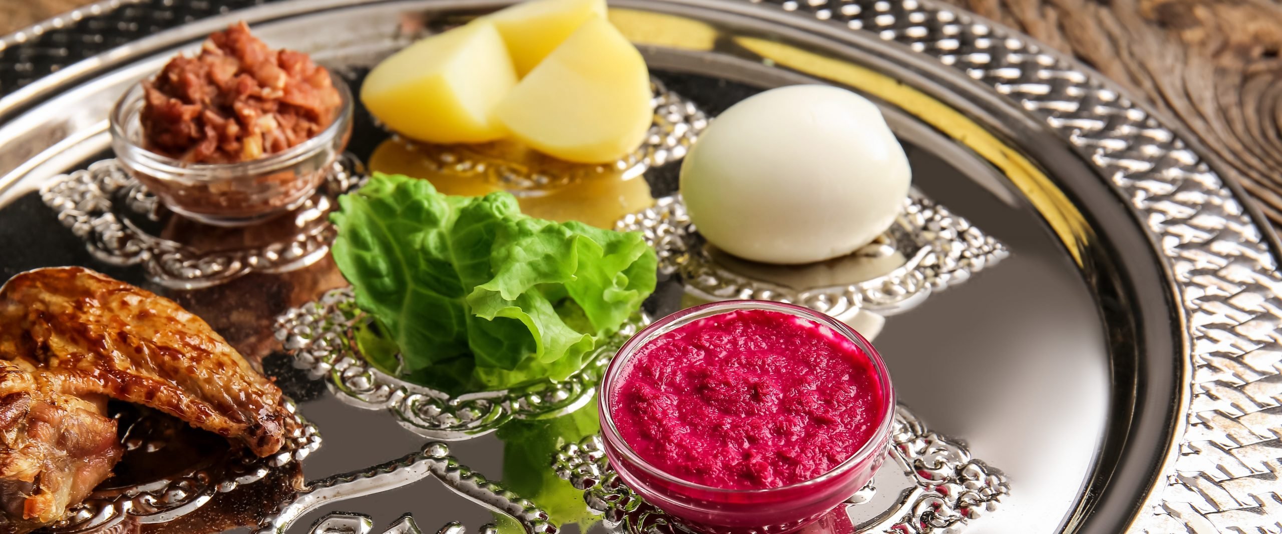 Passover Seder plate with traditional food on table, closeup