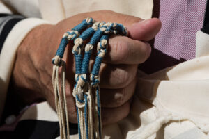 Holding techelet tzitzit during Jewish prayer