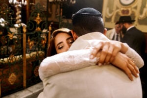 Look from behind on a bride hugging her Jewish groom with closed